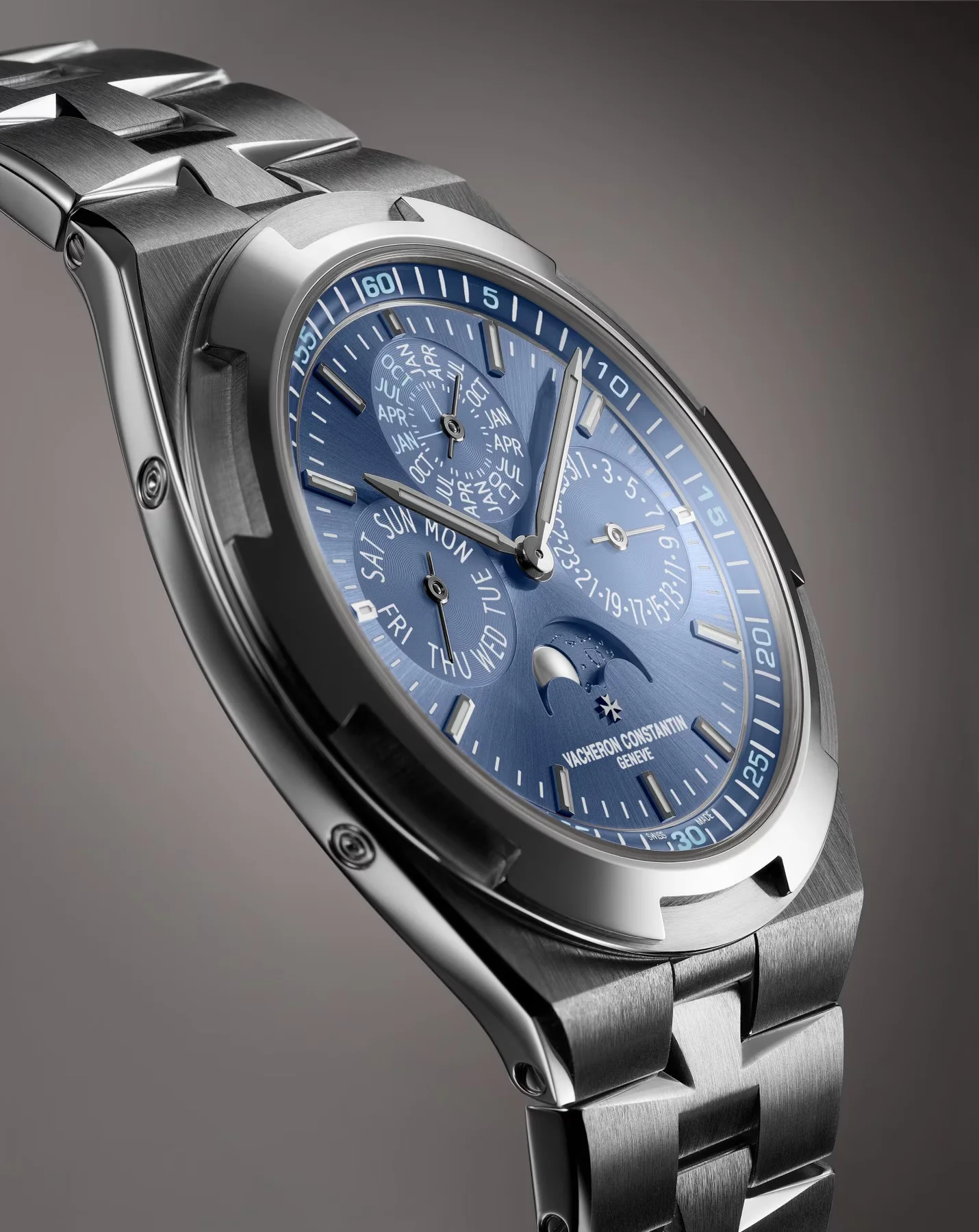 Vacheron Constantin blue dial watch with perpetual calendar, moon phase, and integrated metal bracelet.