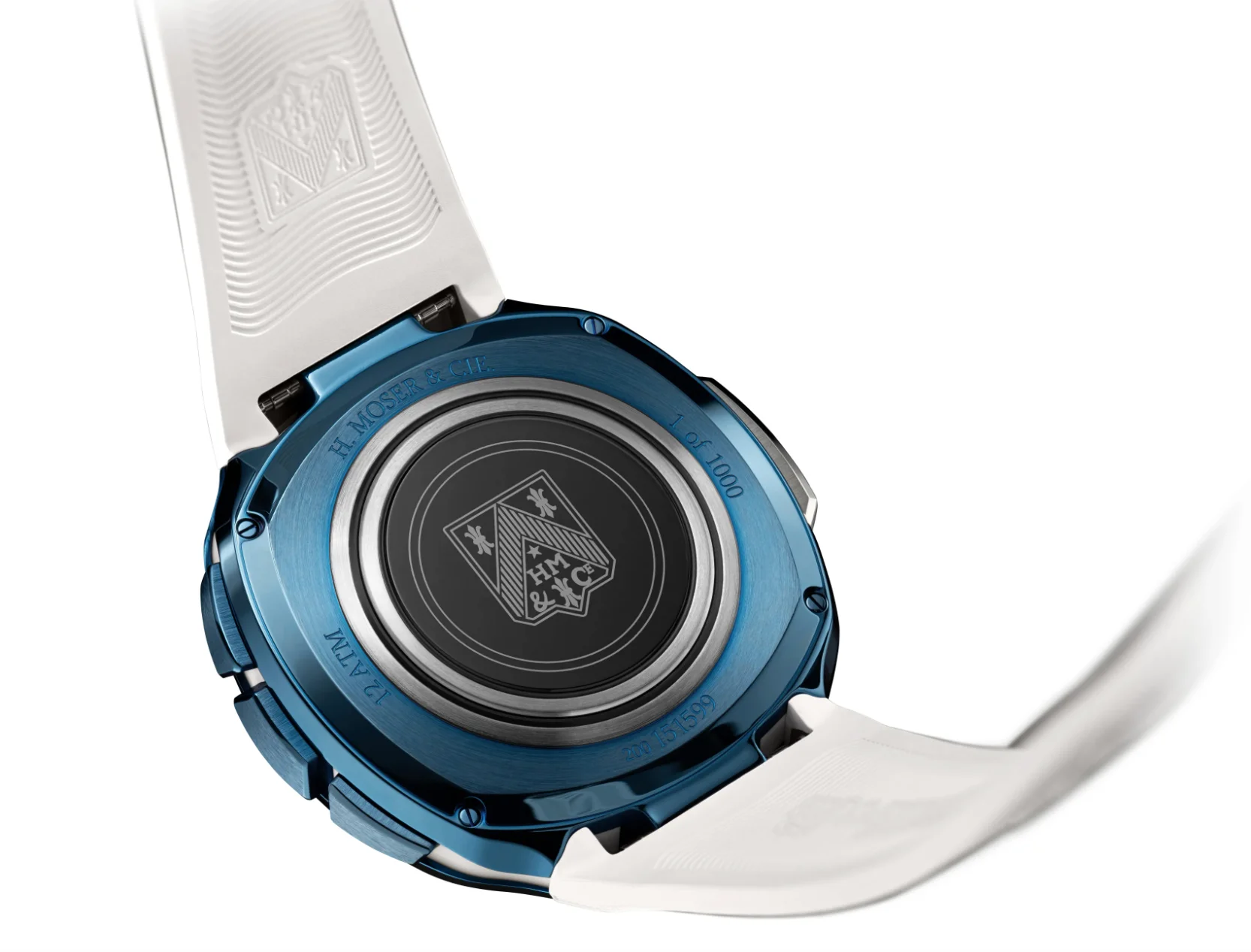 Blue H. Moser & Cie. watch case back with "1 of 1000" engraving, HM & Cie crest, and white textured rubber strap.