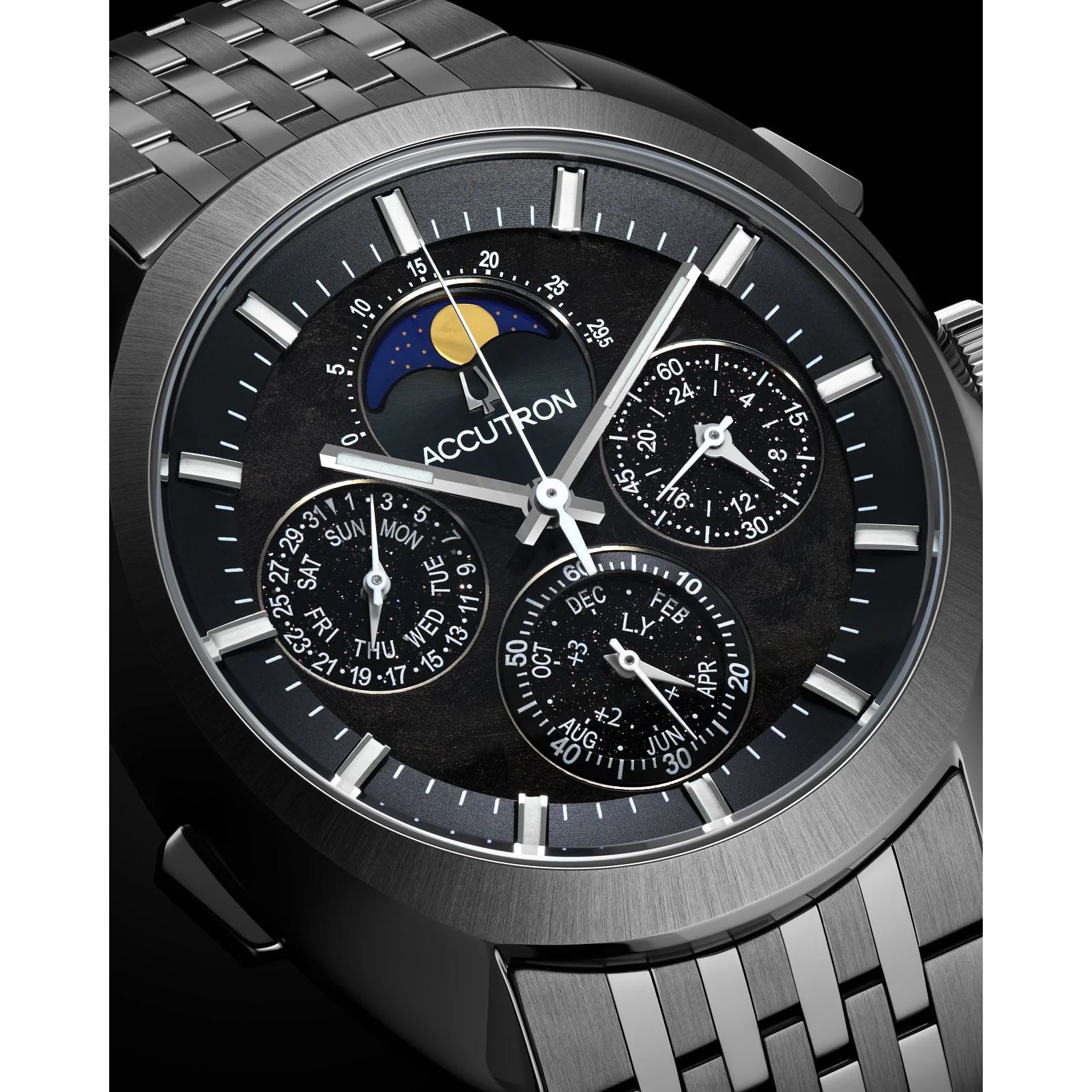Accutron dark grey watch with textured black dial, integrated bracelet. Moon phase, day/date, month, 24hr sub-dials.