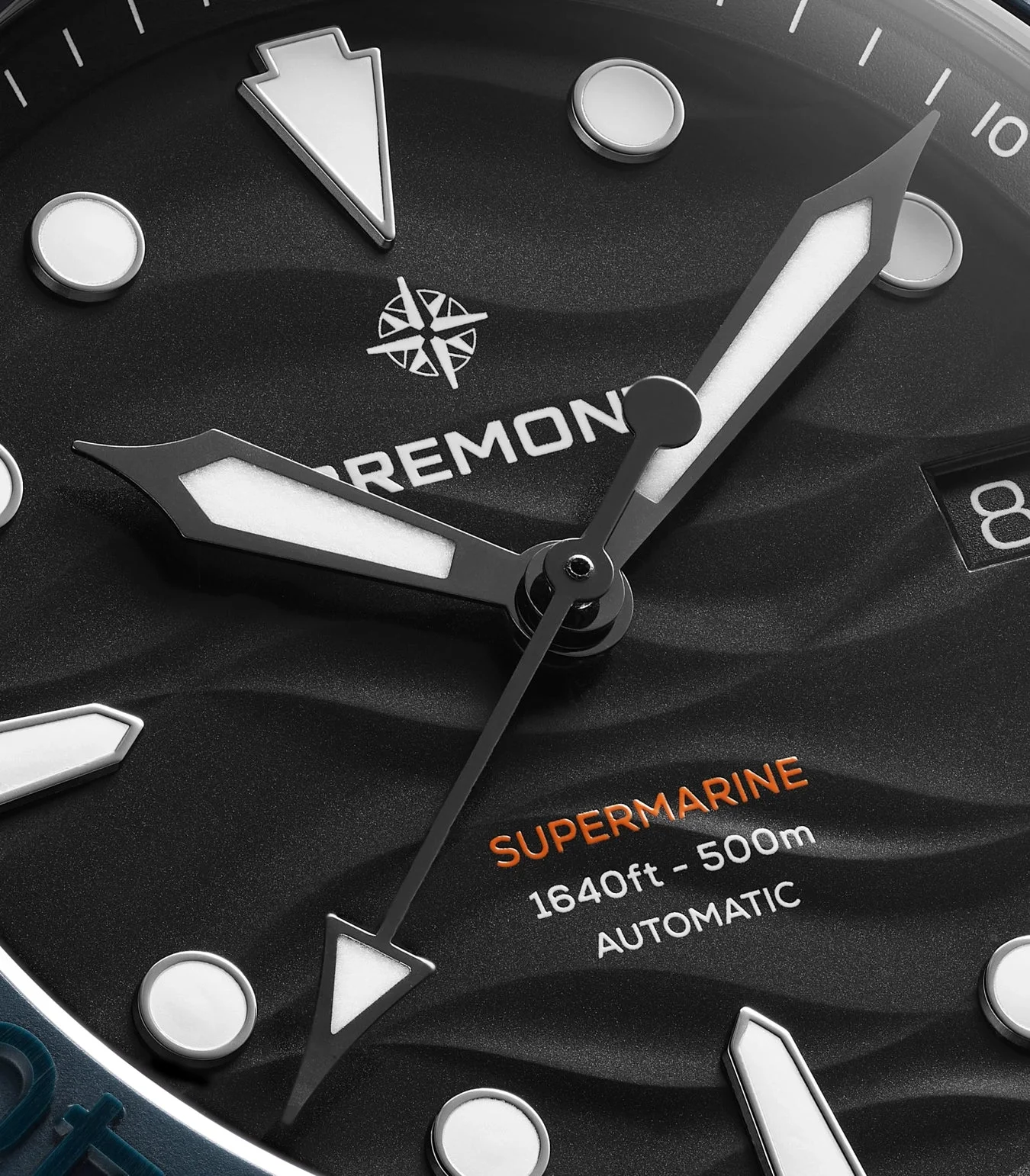 Close-up of a Bremont Supermarine luxury dive watch: black wavy dial, luminous hands, round & arrow markers, date 8.