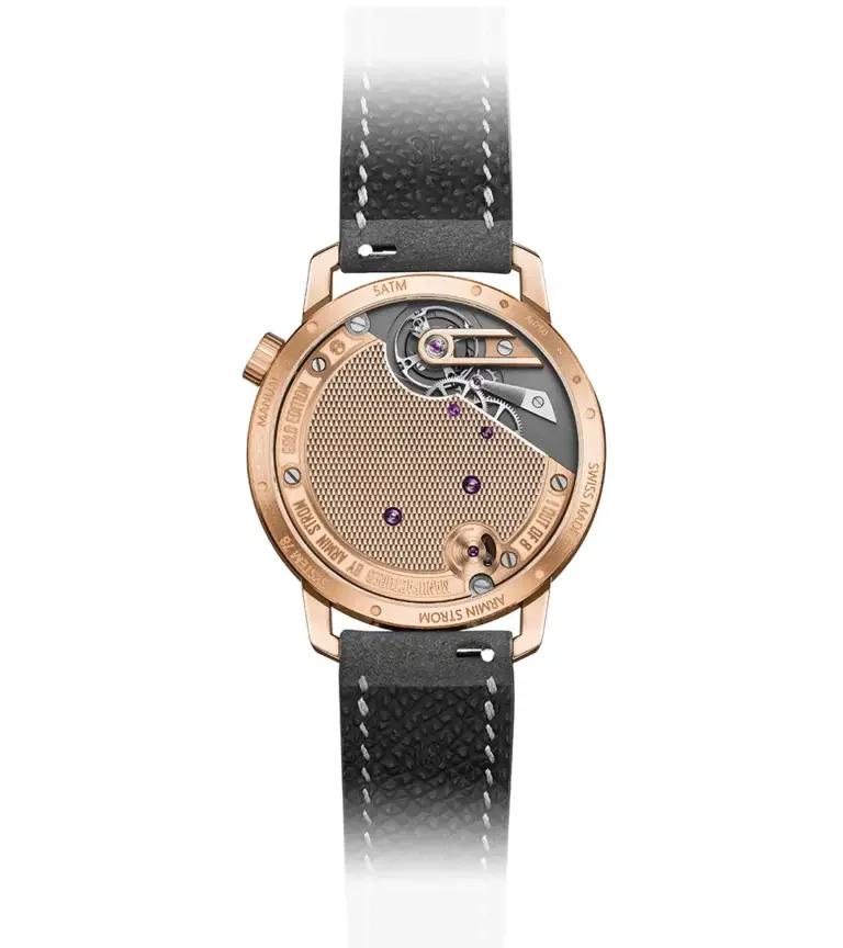 Armin Strom rose gold watch, back view. Intricate mechanical movement, gears, purple jewels, textured gold plate. Black leather strap.