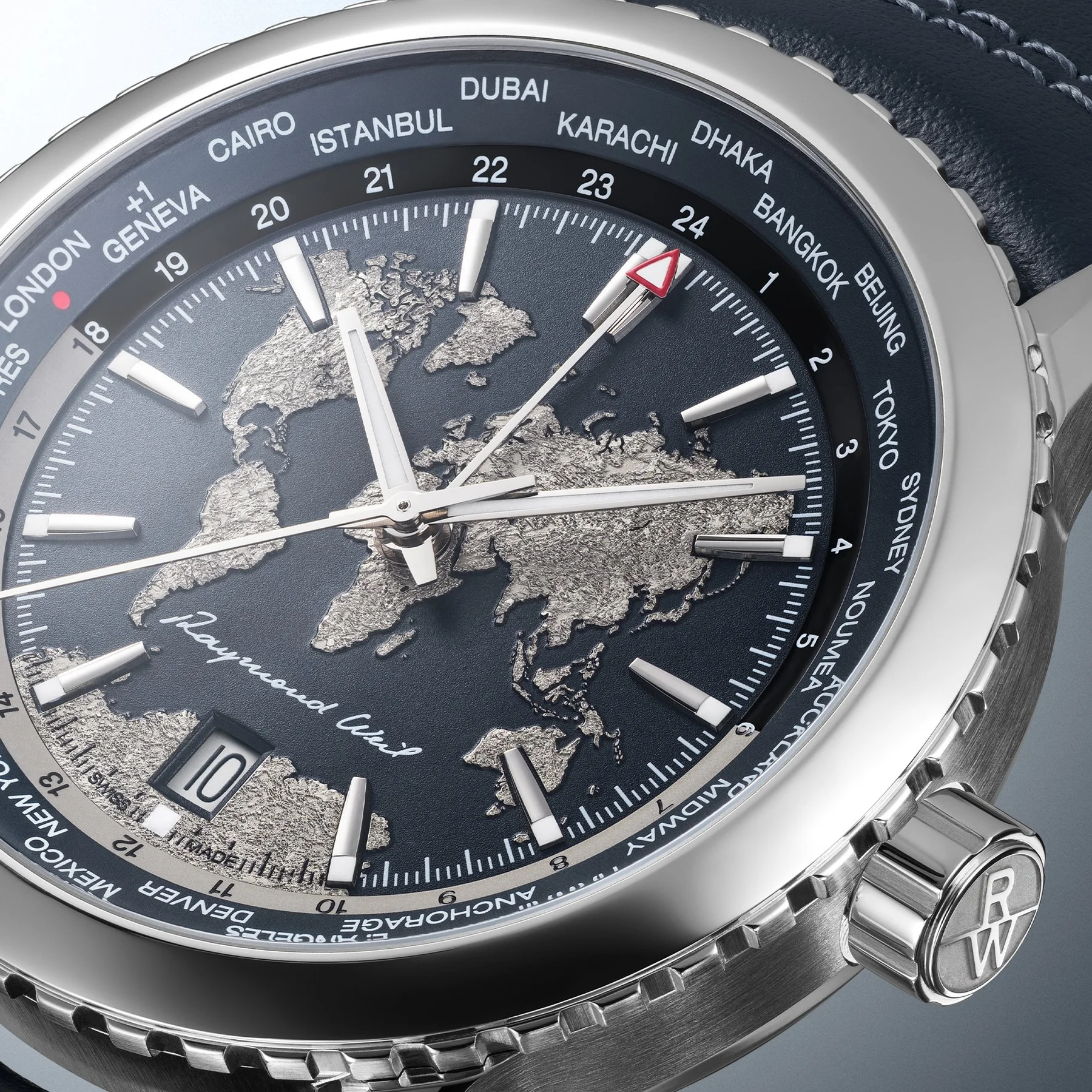 Close-up of a Raymond Weil watch: dark blue dial, silver world map, date 10, city names, steel case & RW crown, blue strap.