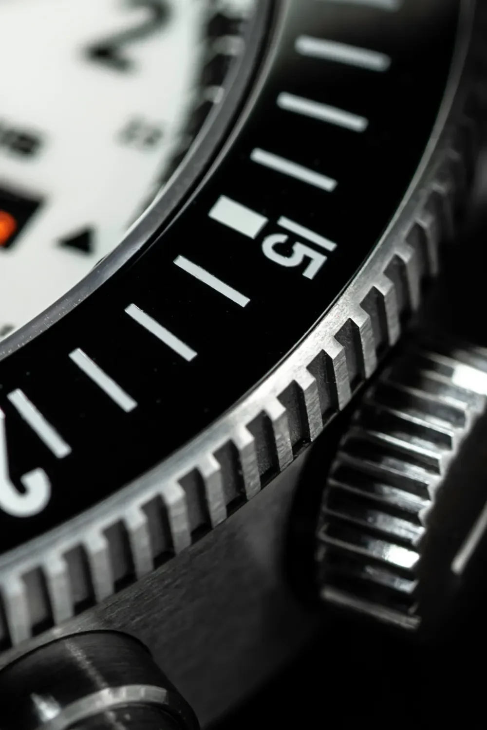 Macro of luxury dive watch: black rotating bezel w/ white 