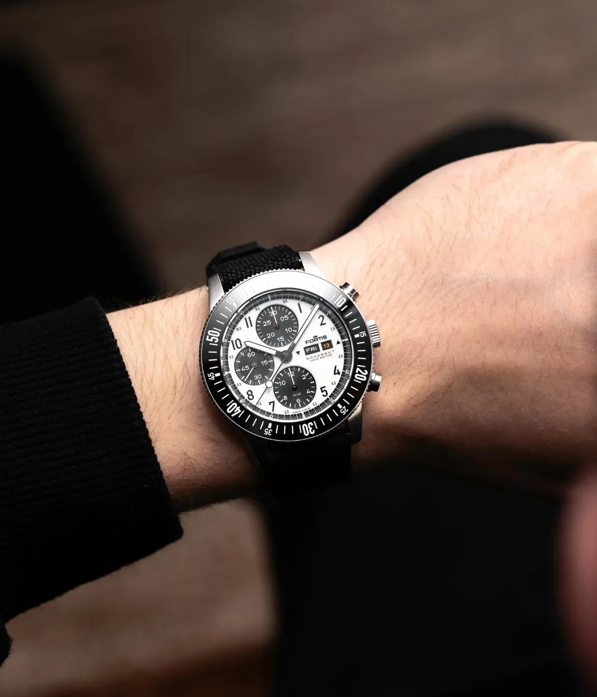 Fortis Novonaut chronograph watch on wrist. White dial, black subdials, day/date, black bezel, textile strap.