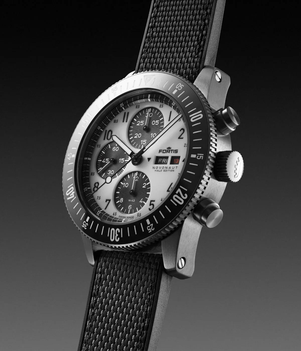Angled Fortis Novonaut Halo Edition chronograph: white dial, black rotating bezel, brushed case, black textile strap. Studio shot.