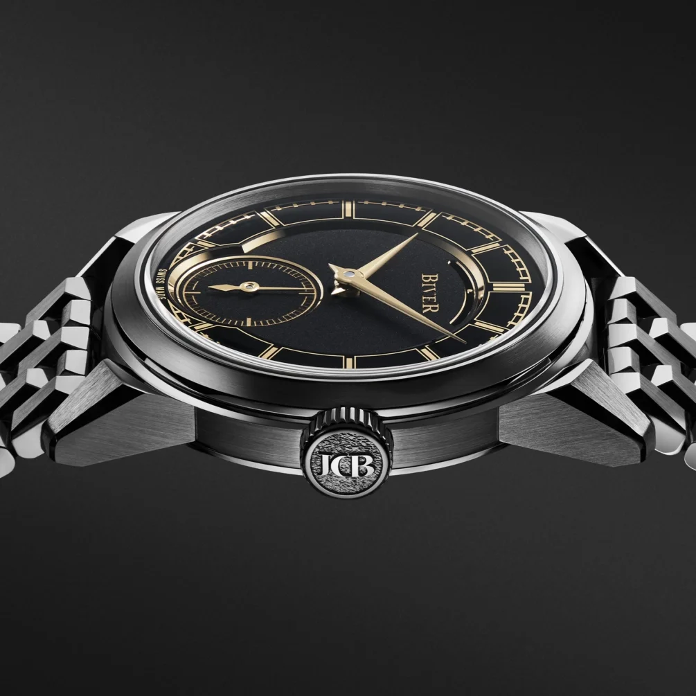 Close-up of a Biver watch, black dial with gold hands & markers, 9 o'clock sub-dial, polished case, metal bracelet, JCB crown.