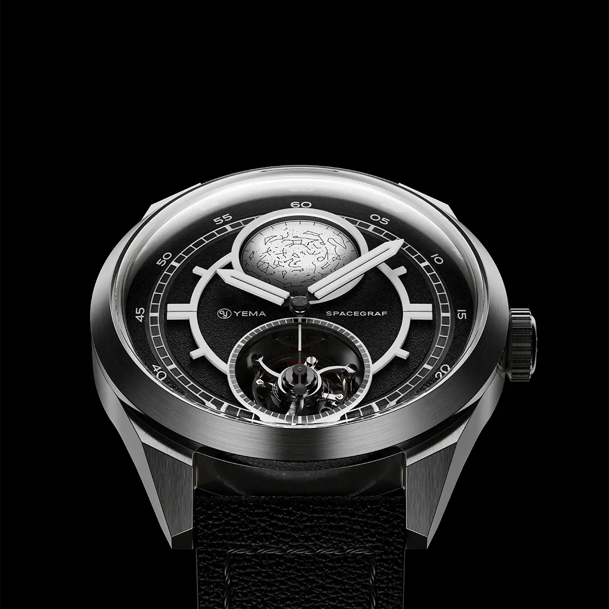 Close-up of YEMA SPACEGRAF watch: black dial, celestial map, exposed tourbillon, steel case, leather strap.