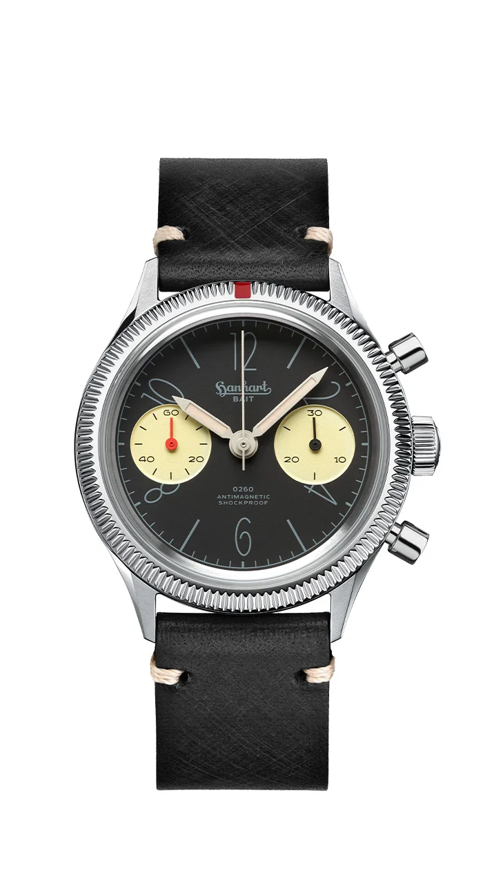 Hanhart 0260 x BAIT chronograph with black dial, cream sub-dials, fluted bezel, red 12-o'clock marker, and black leather strap.