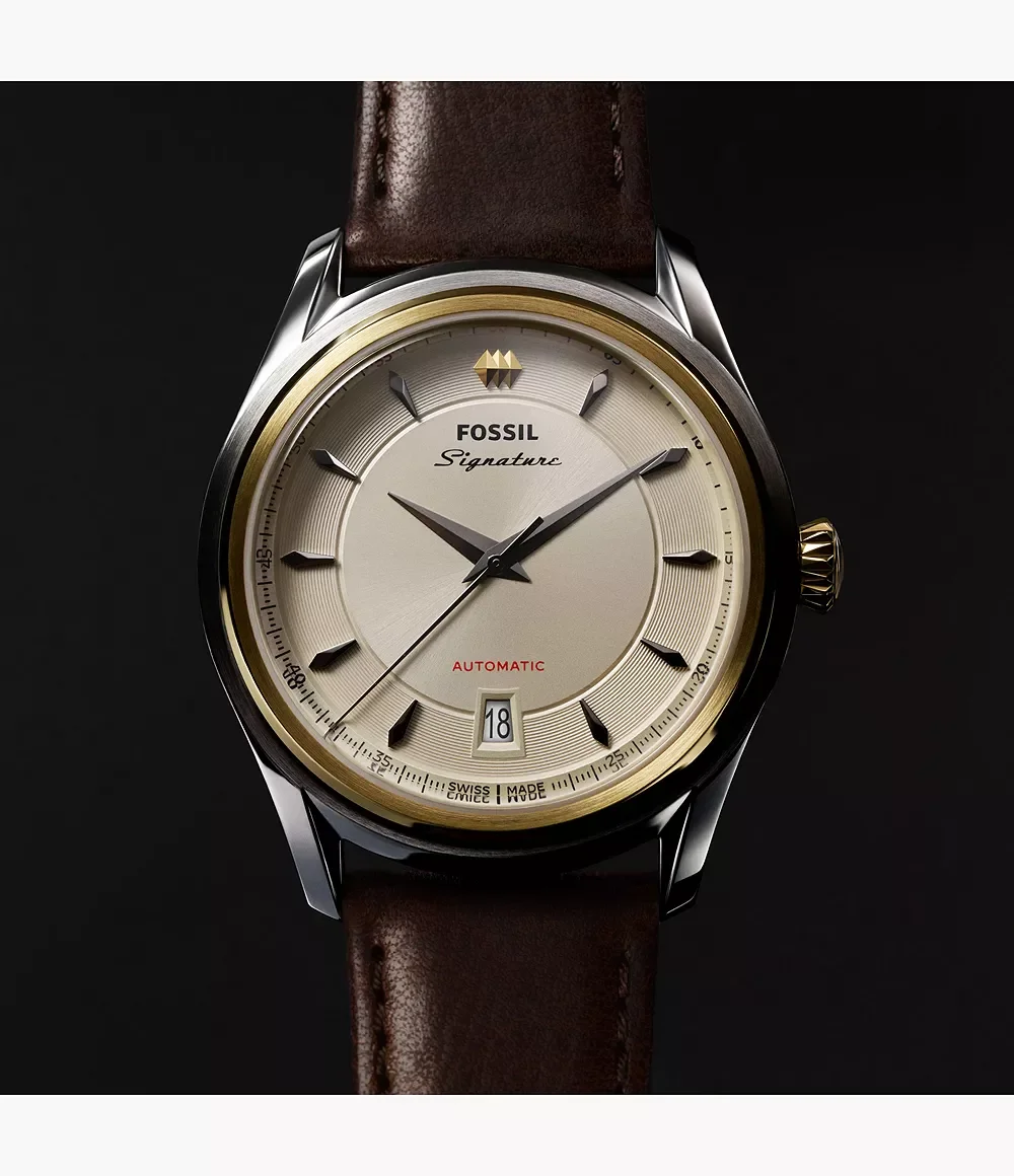 Fossil Signature automatic watch with a champagne dial, gold bezel, silver case, and brown leather strap.