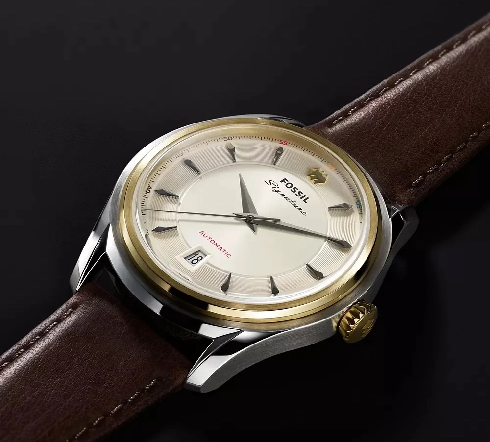 Fossil Signature automatic watch with cream dial, gold bezel, steel case, brown leather strap, date 18, and gold fluted crown.