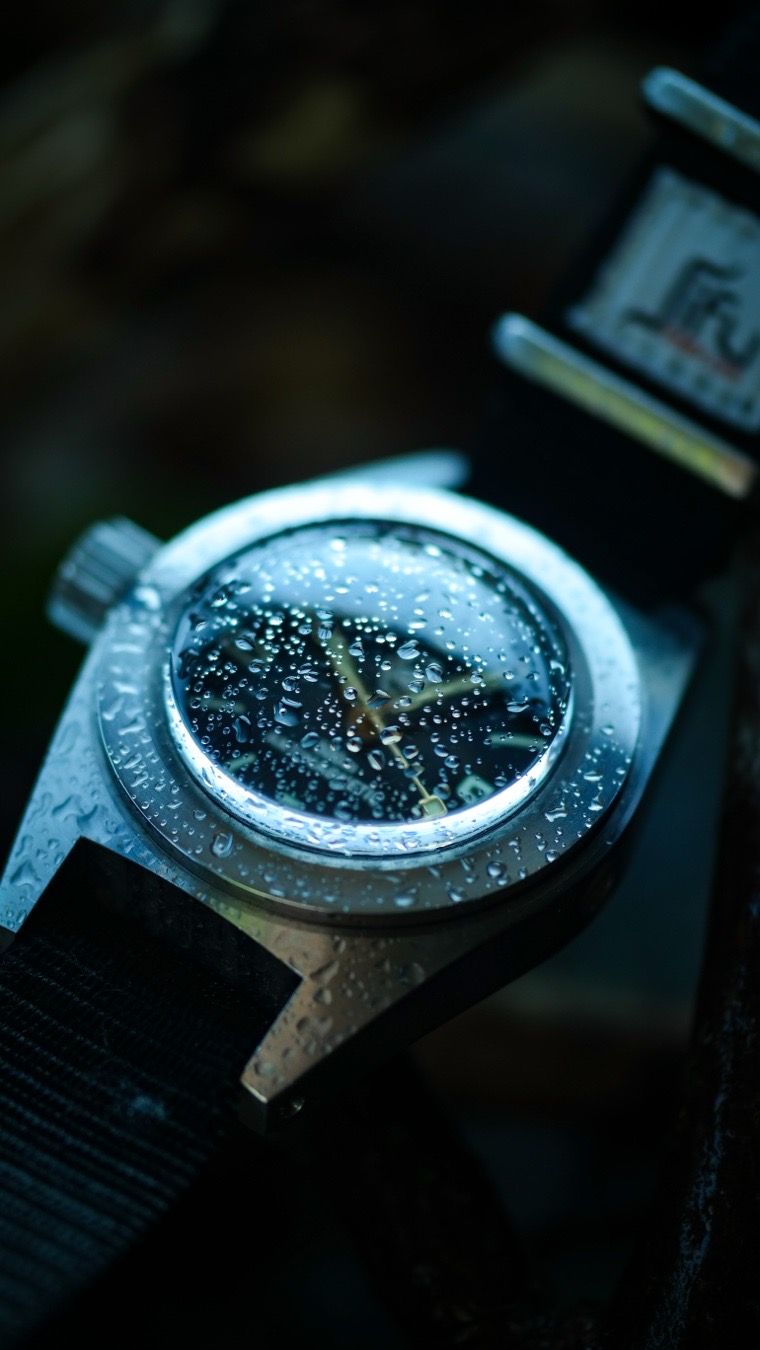 The dial of a Germano & Walter watch is its standout feature, engineered as a soft-iron, anti-magnetic cage component that maximizes both legibility and mechanical protection.

The Core Concept: The Soft-Iron Dial
Far more than just a surface for telling time, the Germano & Walter dial is an integral part of the timepiece’s structural and technical architecture.
* Anti-Magnetic Shielding: Like the brand’s legendary 500m dive watch, the dial forms the front of a soft-iron (ferromagnetic) inner cage that surrounds and protects the movement. Coupled with a specialized inner case and movement cover, the dial shields the delicate mechanics from strong magnetic fields.
* Extreme Visibility: The dial is optimized for ultimate legibility. Whether opting for the classic matte black or a hand-engraved variant, it serves as a canvas designed for high contrast.
* Luminescent Application: The dial is printed with a thick application of high-grade luminous phosphor (Super-LumiNova). This ensures instant readability in the pitch black depths of the ocean or during low-light conditions.

Design Elements and Layout

* Minimalist Approach: Renowned for its clean, purposeful aesthetic, a typical Germano & Walter dial eschews clutter. Many iterations feature no numerals at all, relying solely on stark, geometric indices paired with the soft-iron backdrop.
* Signature Hands: The dial is complemented by oversized, distinctively shaped hands that are generously coated with luminous phosphor to match the dial markers.

*The diameter of the dial is generously sized at roughly 30.5 mm to 35 mm, filling out the watch’s robust 42 mm case to make it the absolute focal point of the piece.

Every Germano & Walter timepiece is handcrafted in small batches, meaning no two dials are entirely identical. 

The dial, hands, and domed crystal work in tandem to create a utilitarian piece of wearable art. By utilizing a separate inner case, the domed crystal is held on both sides, protecting the dial and movement against dangerous pressure build-ups during deep dives.

