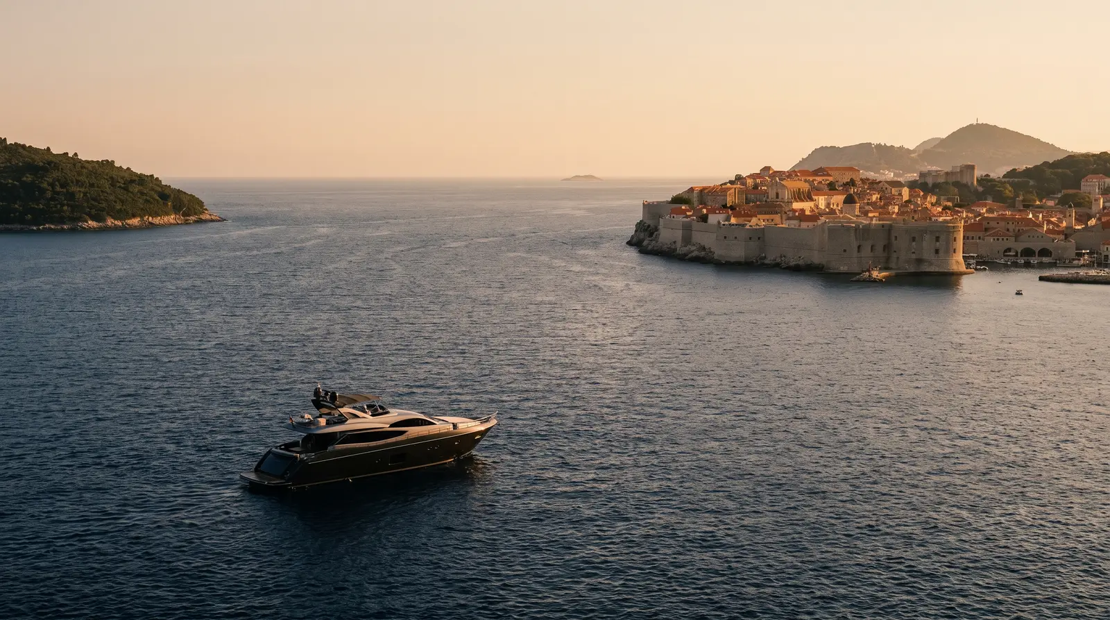 Motor yacht passing the old town walls of Dubrovnik