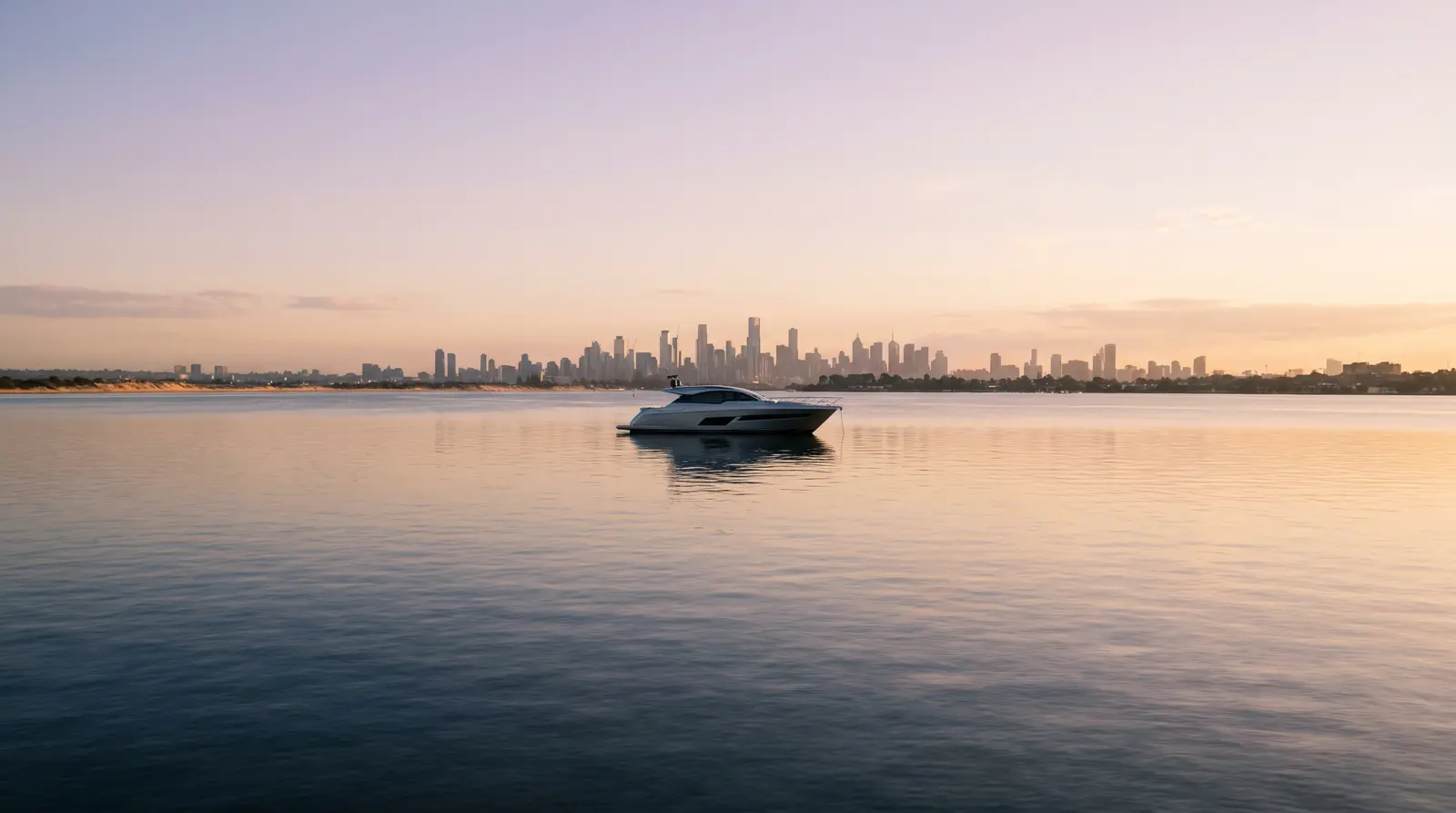 Motor yacht on Port Phillip Bay with the Melbourne skyline at dusk