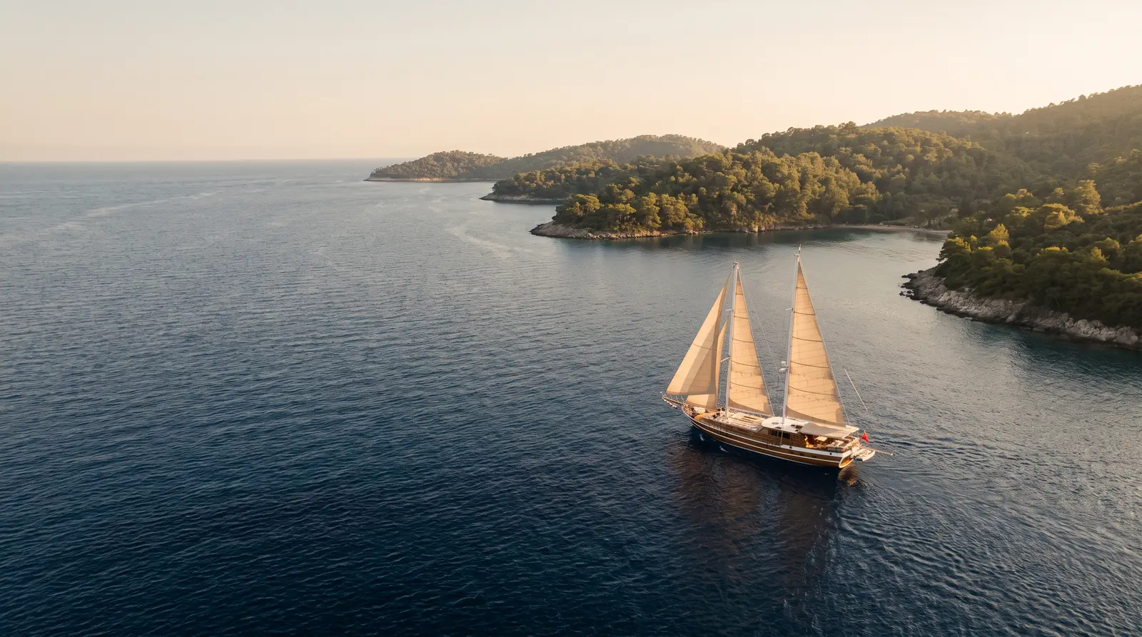 Gulet sailing along a green coastline