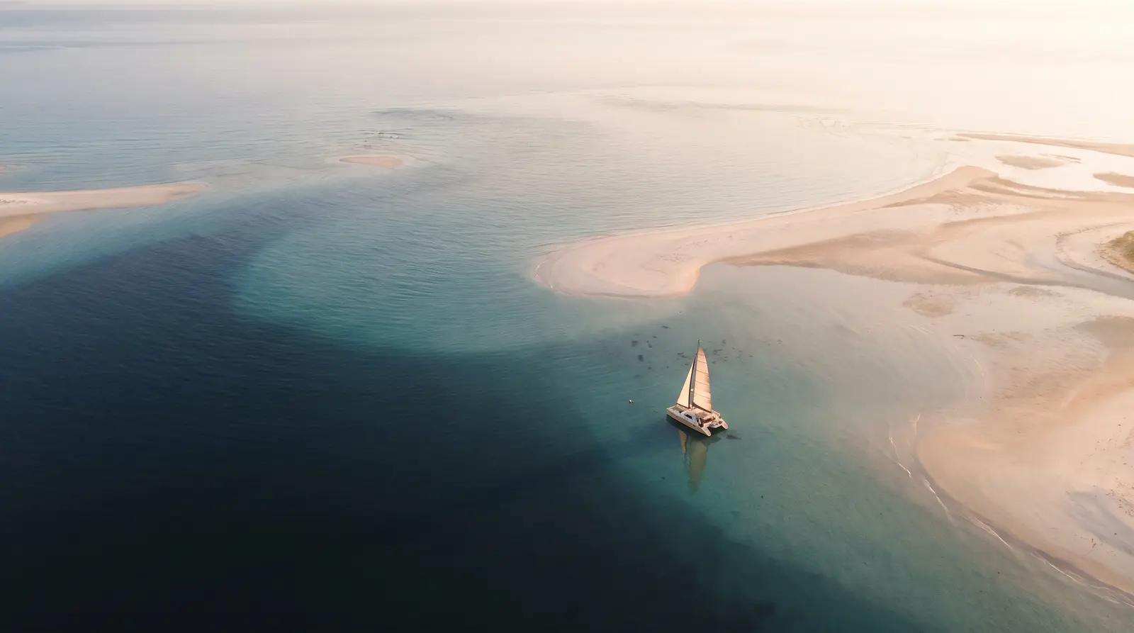 Sailing catamaran anchored off the swirling sands of Hill Inlet, Whitsundays