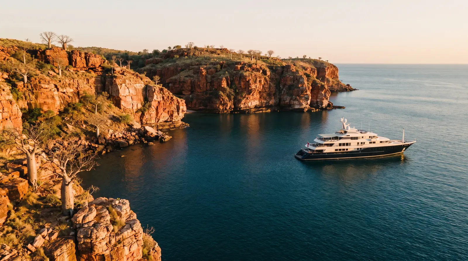 Expedition yacht beneath the red cliffs of the Kimberley coast