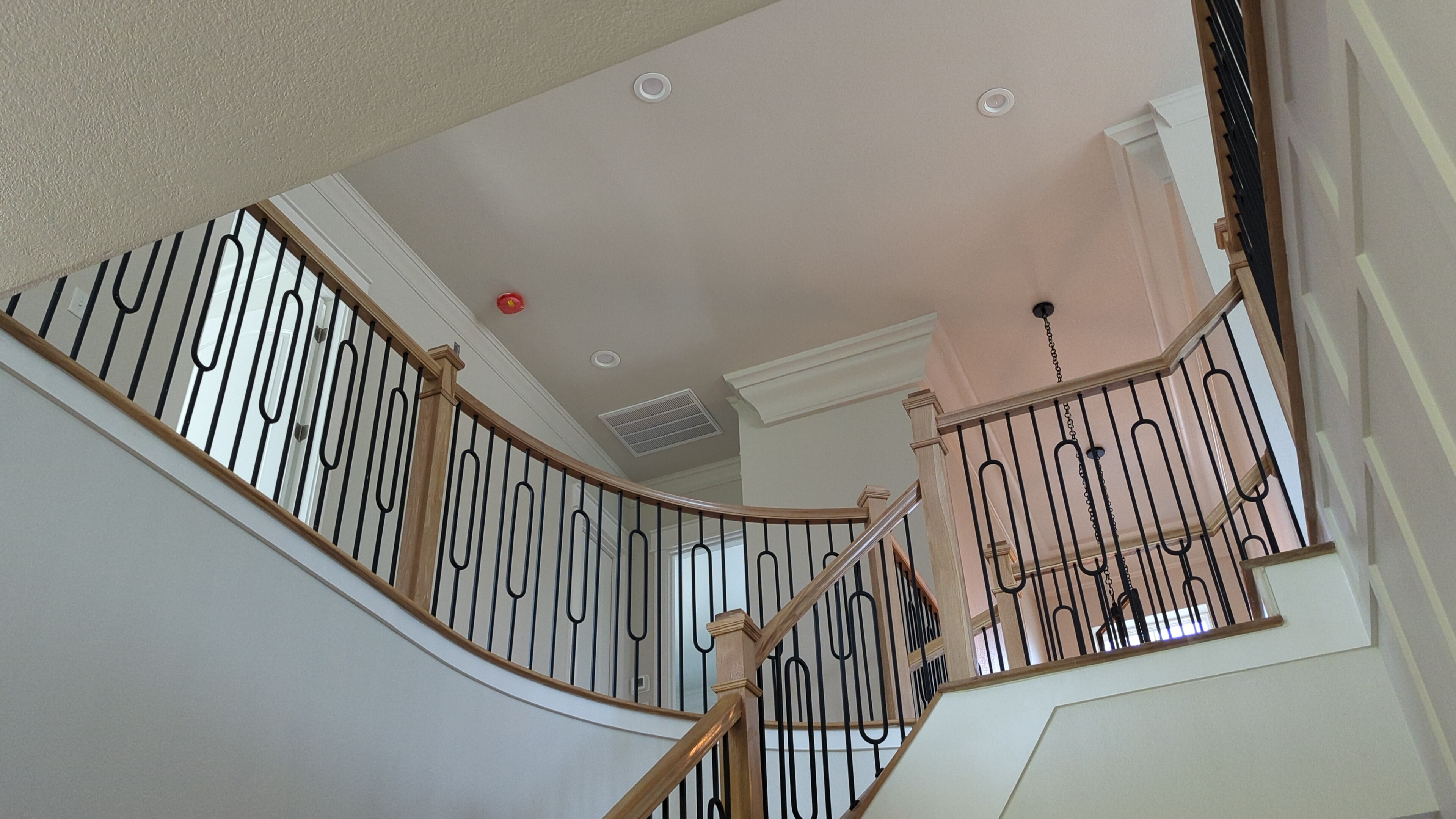 Interior view of a modern home, looking upwards towards the second floor and staircase railing