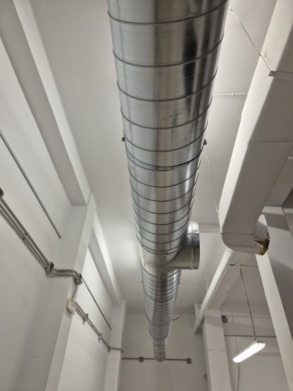 A modern bathroom with a wooden vanity and a round mirror.