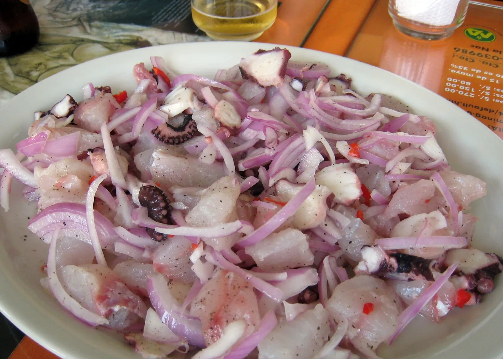 A plate of Lima ceviche with white fish, octopus, red onion and chili