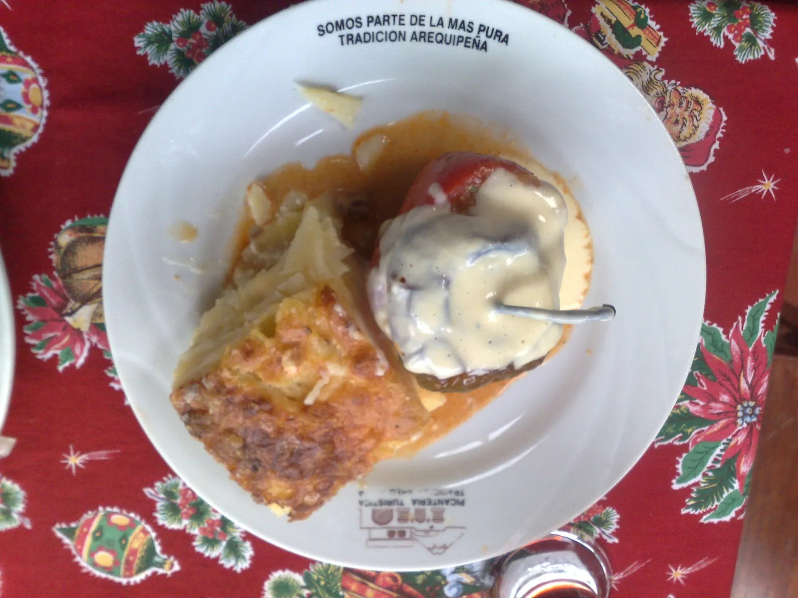 Rocoto relleno com queijo derretido e uma fatia de pastel de papa numa picantería de Arequipa