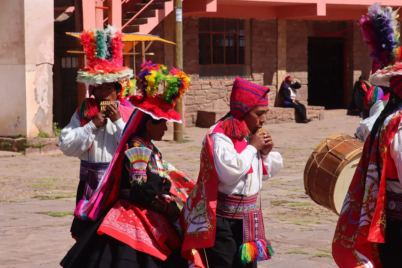 Musicians from Taquile in woven belts and knitted caps, playing panpipes in the island's square