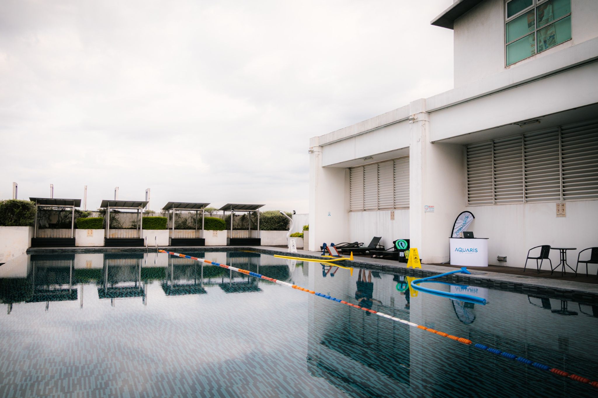 Coach guiding an adult learner in the pool at Aquaris Swim Academy