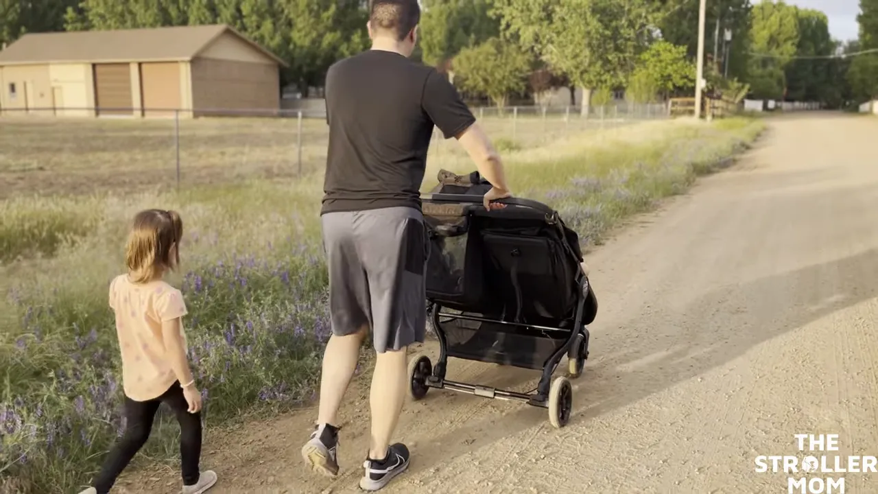Dad pushing side by side Baby Jogger GT2 Double on dirt road