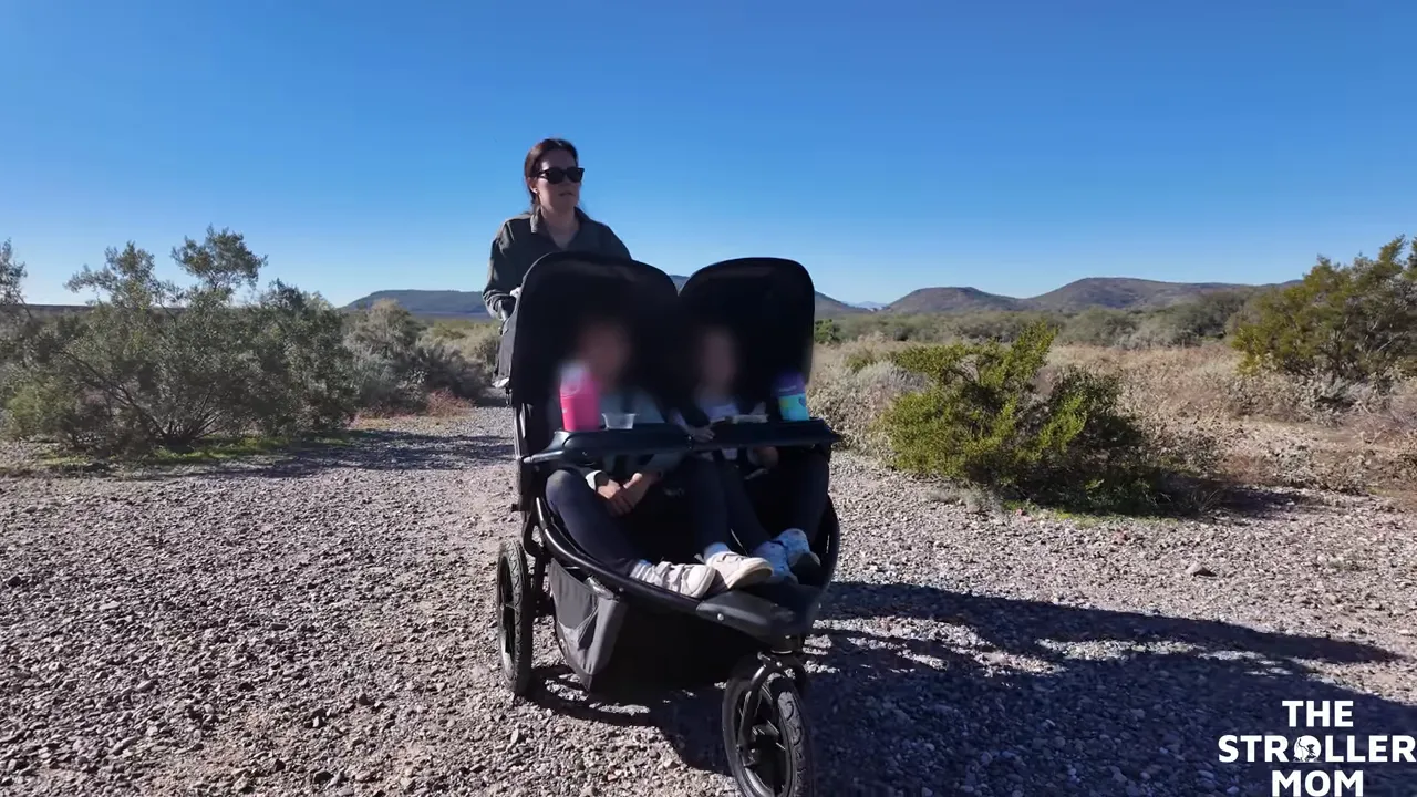 Side-by-side double jogging stroller out on rocky terrain