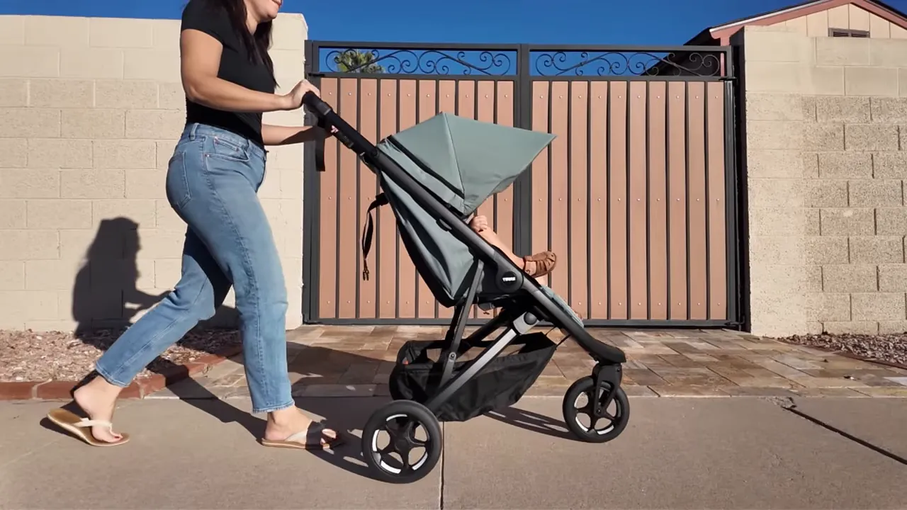 Mom walking with Thule Spring 2 showing three-wheel maneuverability