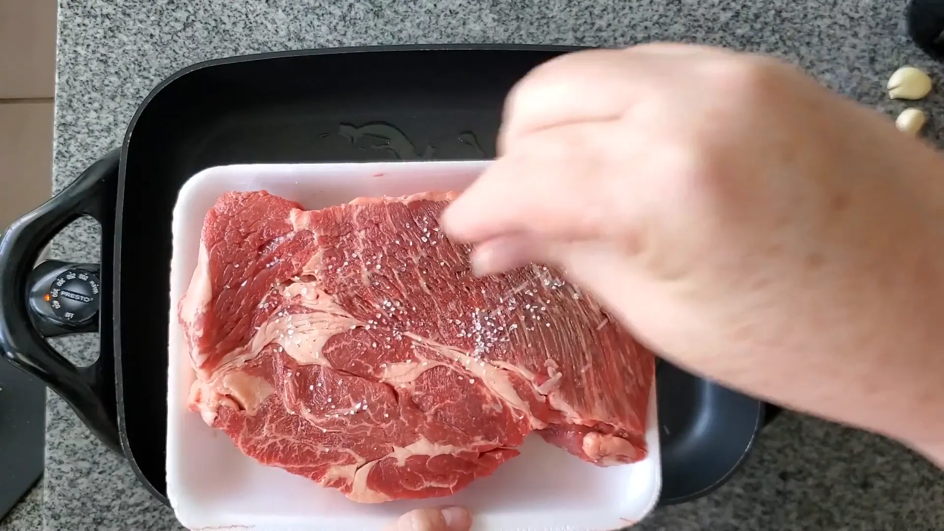 Seasoning the chuck roast with salt and pepper.