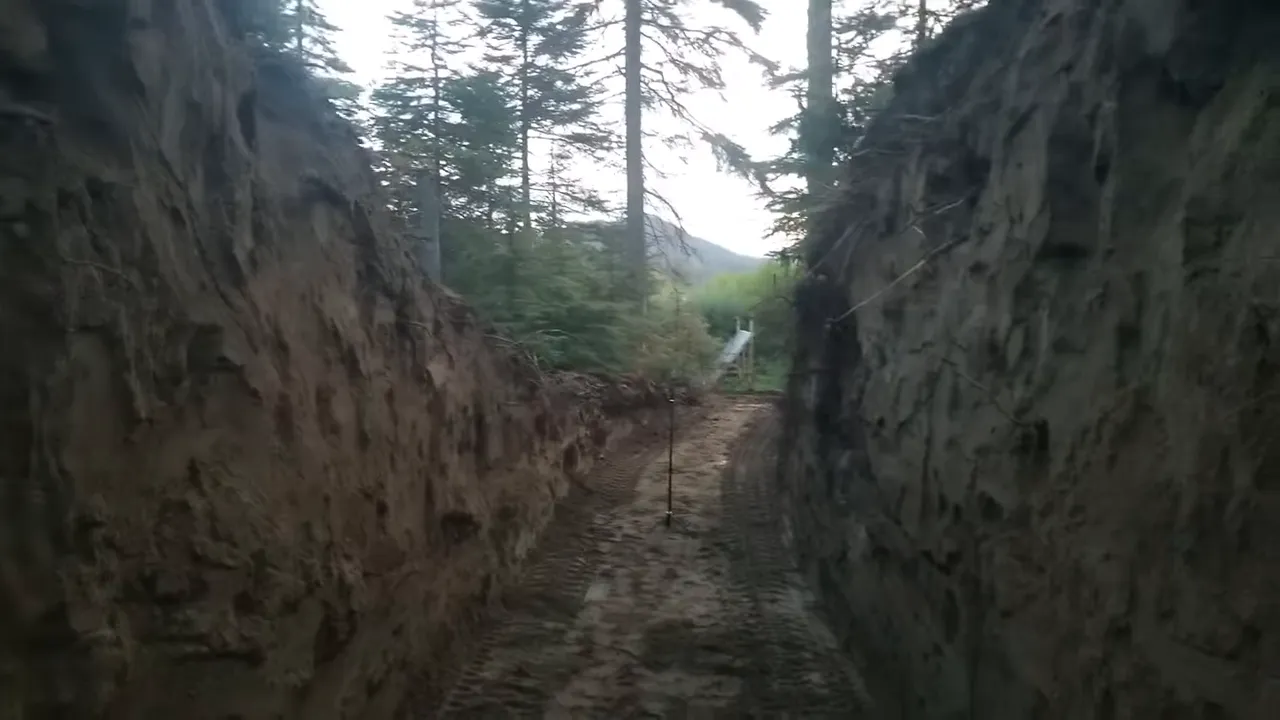 Off grid life - wide view from above of a large excavated pit with sloped sandy walls