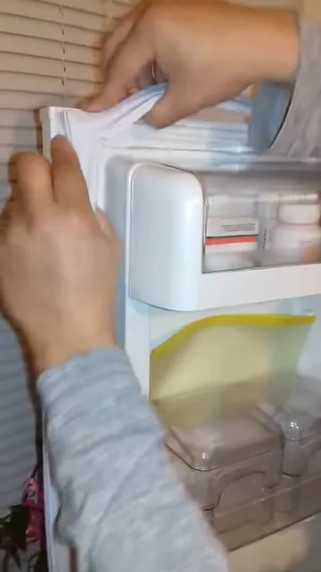 Руки встановлюють новий ущільнювач у верхній кут дверей холодильника