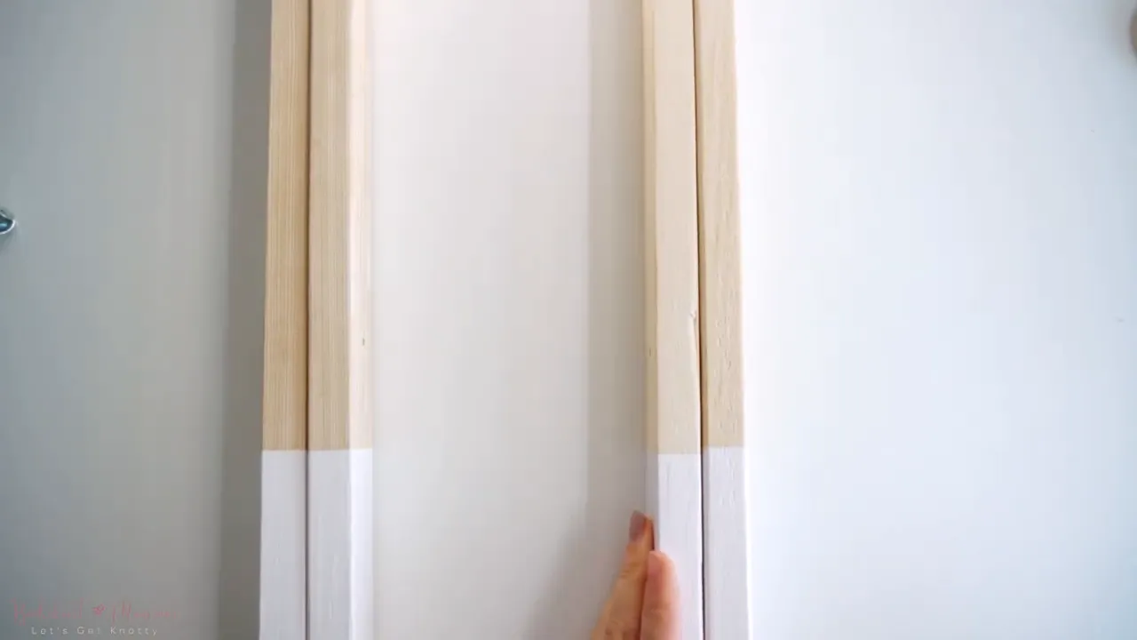 two wooden legs crossed and fastened with a screw and washer to create a hinged side frame