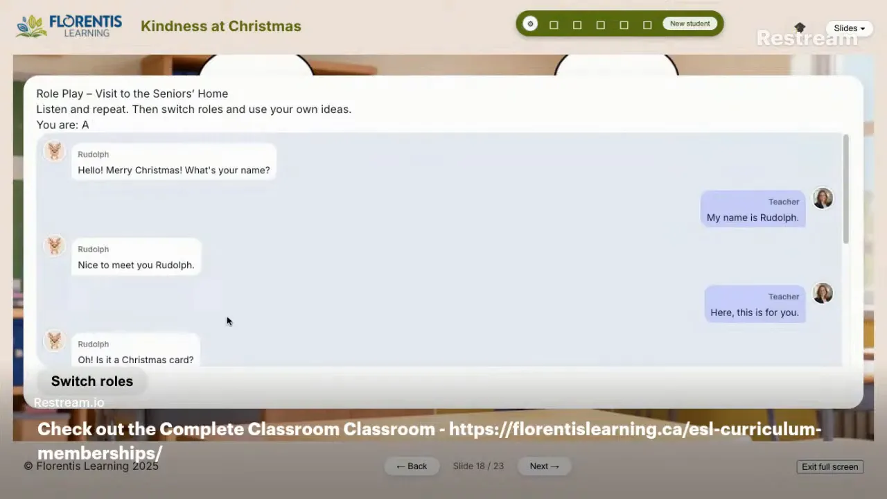 Virtual lesson slide showing a Christmas tree, elf, wrapped gift and speech bubbles reading 'What is it?' and 'It is...' with teacher video thumbnails at the sides.