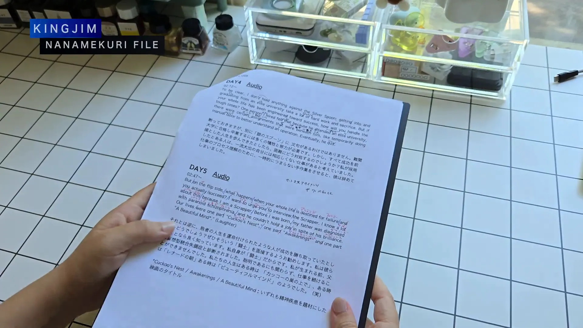 キングジムのA4ナナメクリファイルの黒いファイルを片手で持っている様子