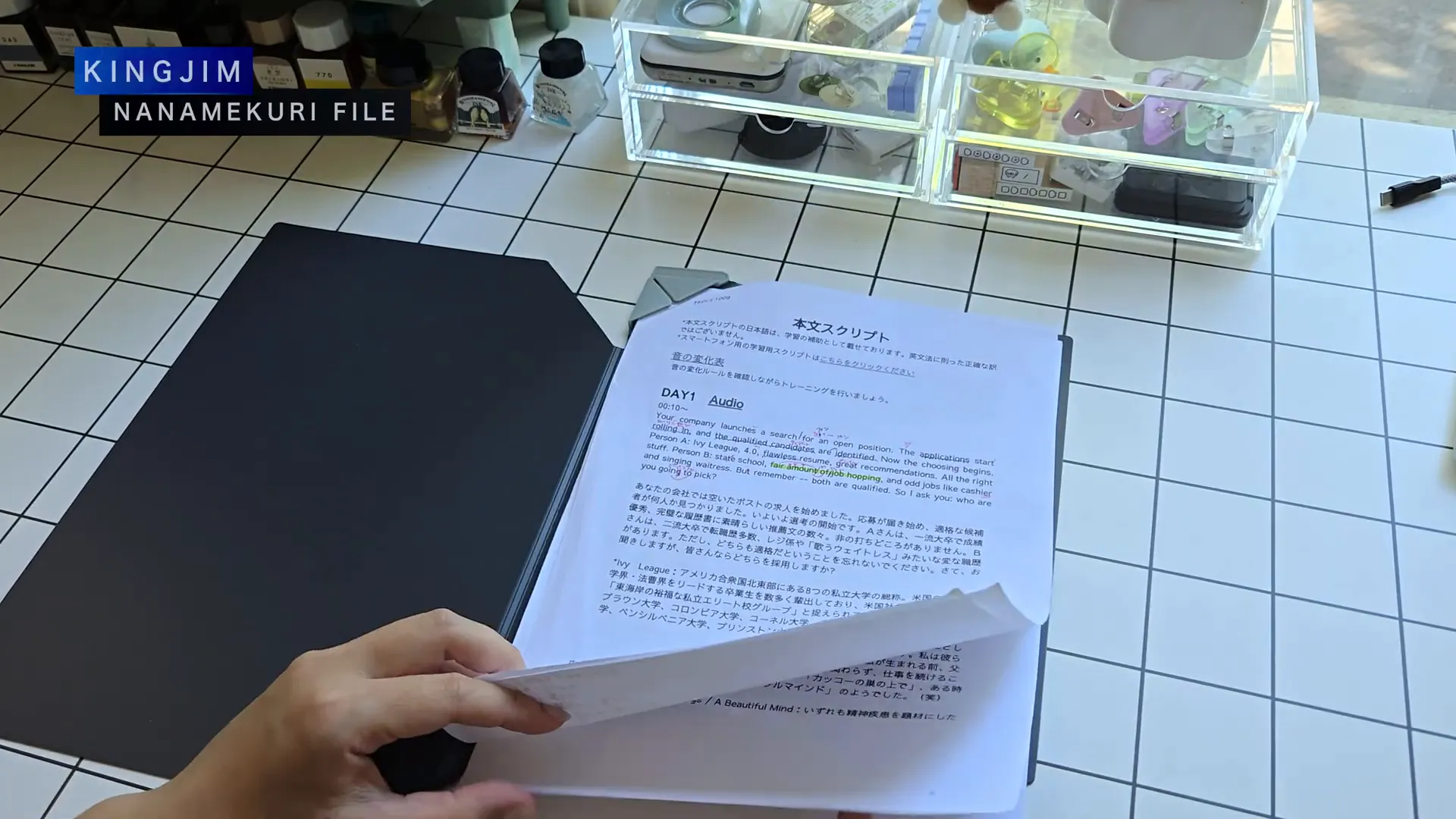 キングジムのA4ナナメクリファイルの黒いファイルを片手で持っている様子