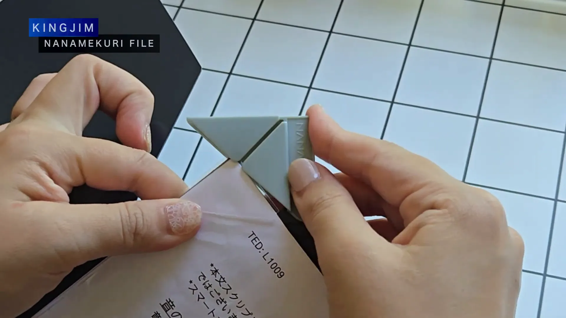 キングジムのA4ナナメクリファイルの黒いファイルを片手で持っている様子