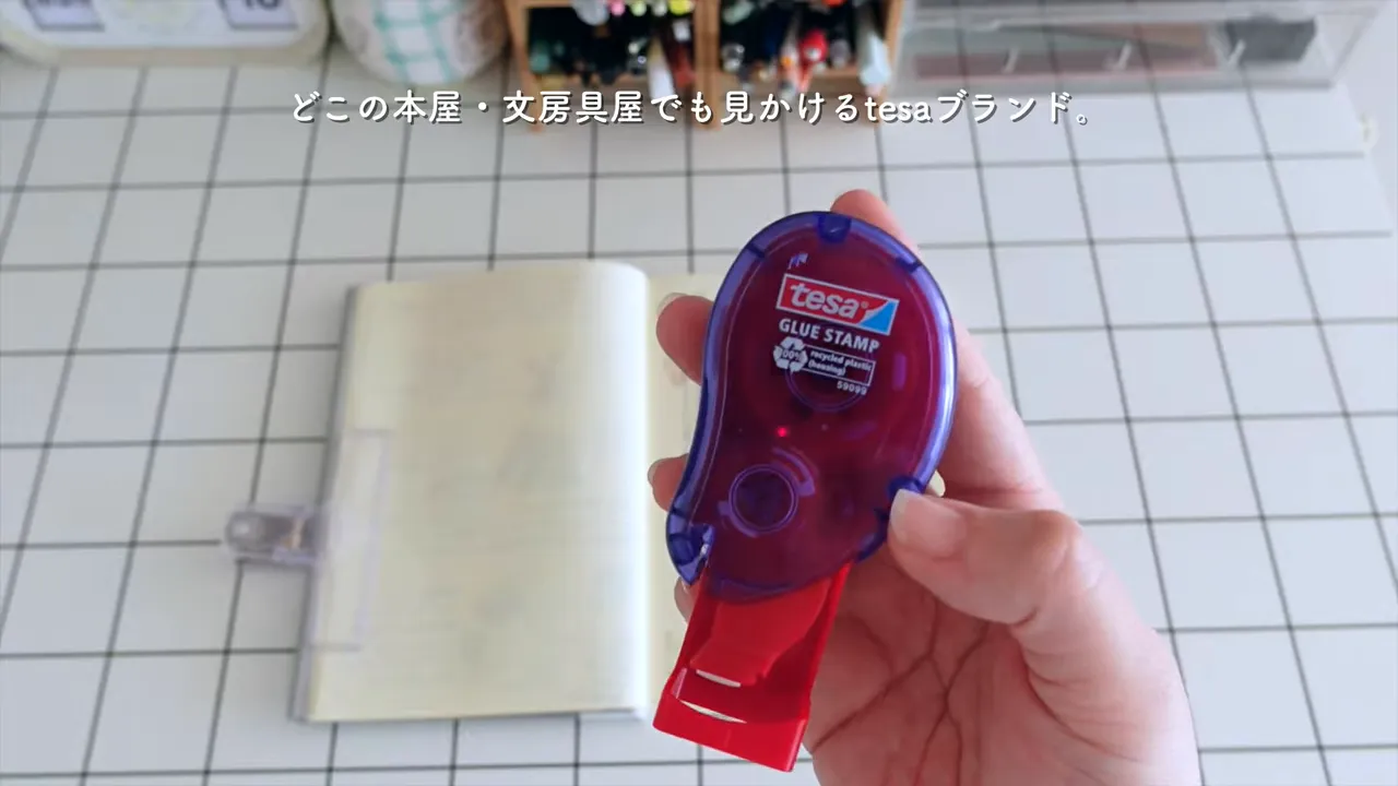 tesaのスタンプのりで紙に押し付けて貼る様子