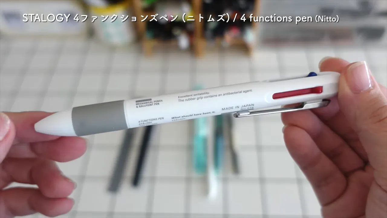 白い多機能ペンの上部キャップを外して小さな消しゴムを見せている