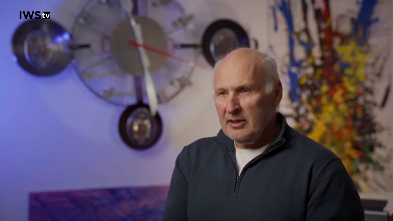 Presenter seated with sample bottles and a glass of calvados on a table while explaining fermentation