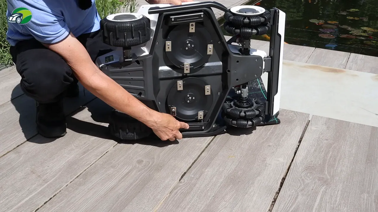 Underside close-up of Luba 2 robotic mower showing dual cutting discs, blade holders and mounting points