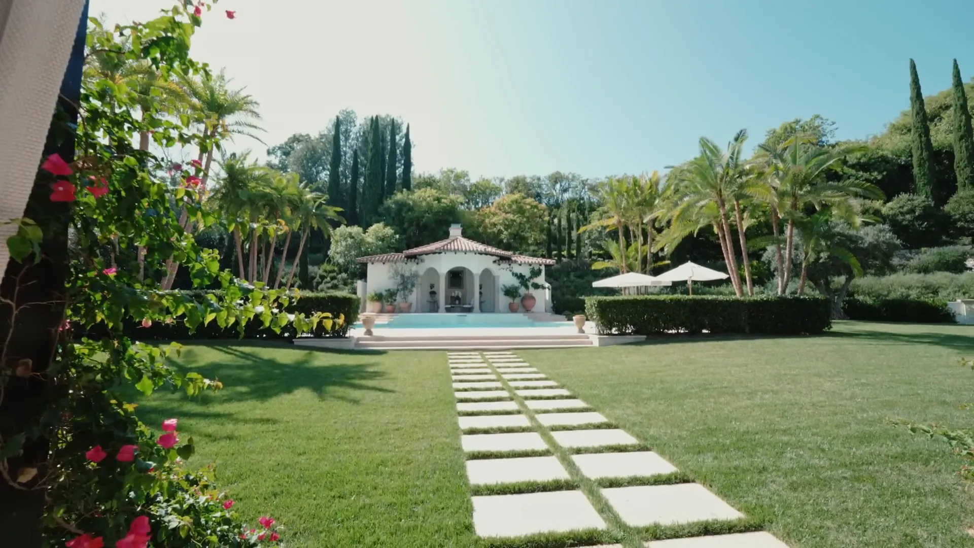 The inviting pool area surrounded by lush greenery.