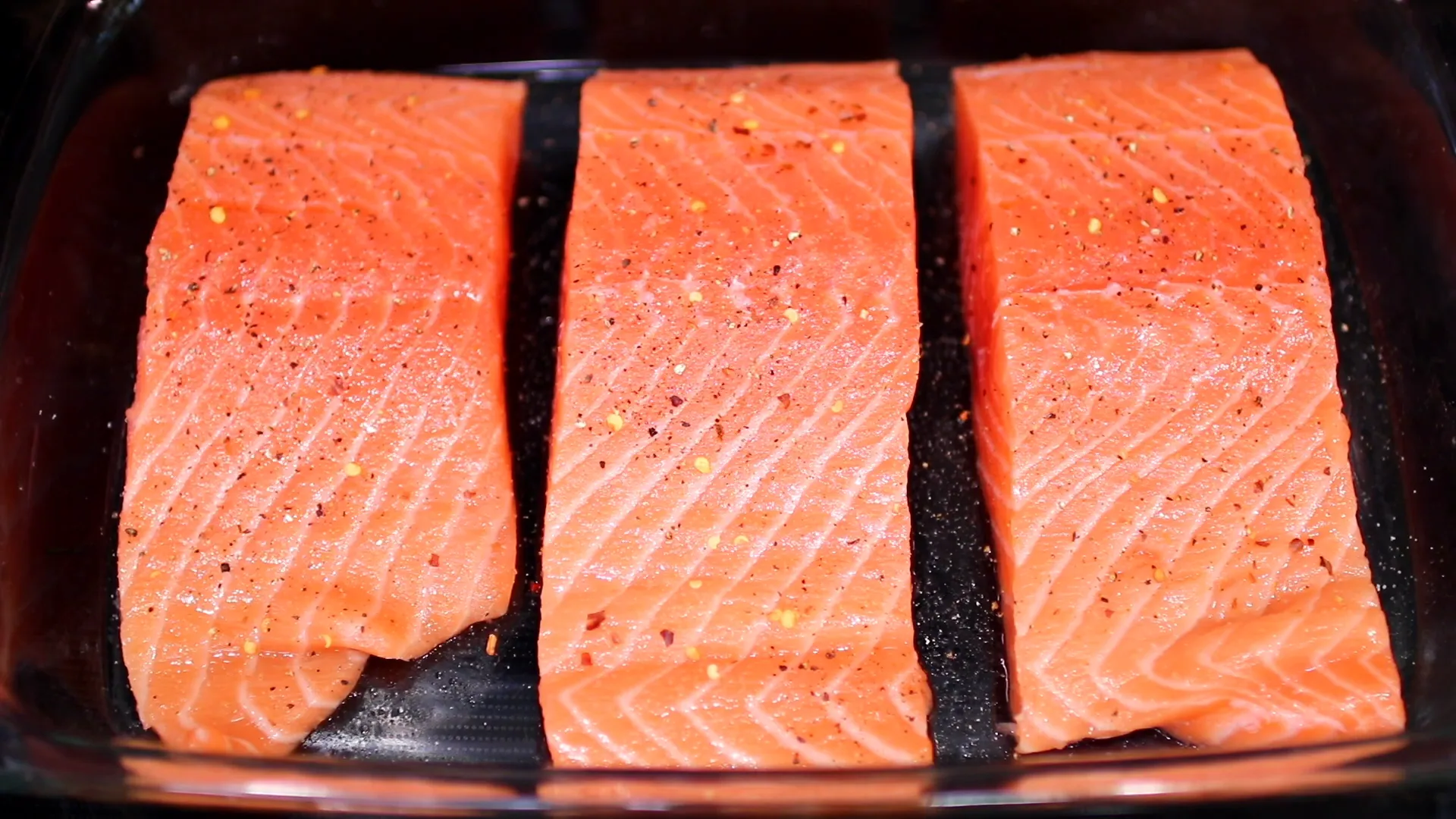 Adding red pepper flakes to the salmon