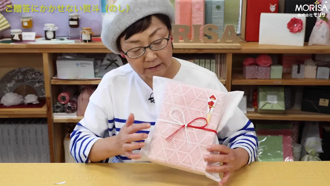 包みの上にのしを丁寧に置く講師のショット（のしが箱の上にある）