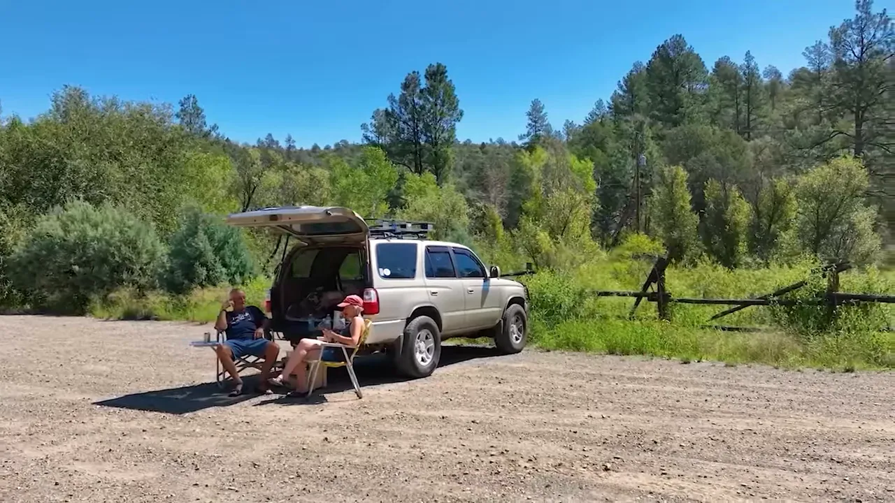 Curving landscaped entry road with central island, sidewalks and mountain backdrop