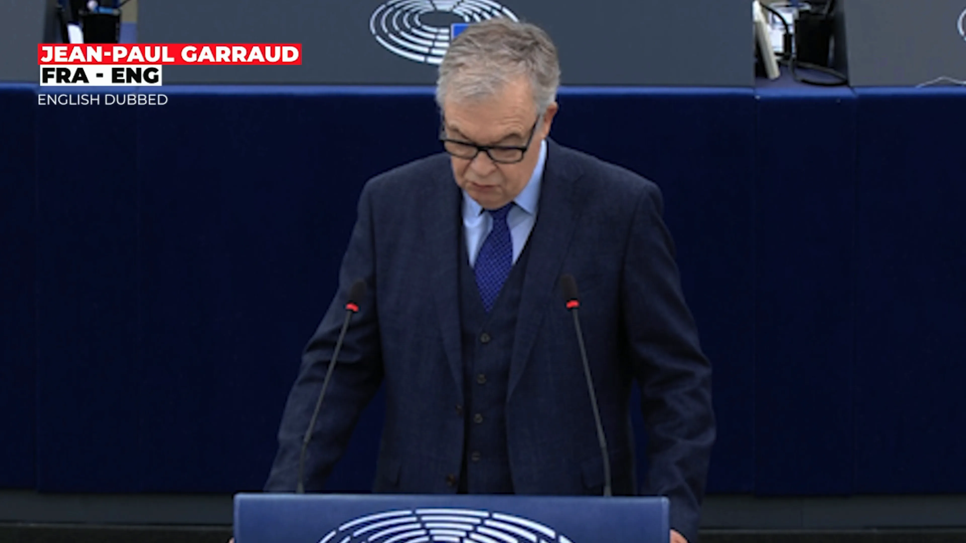 Member of the European Parliament speaking at a podium during debate on Syrian returns