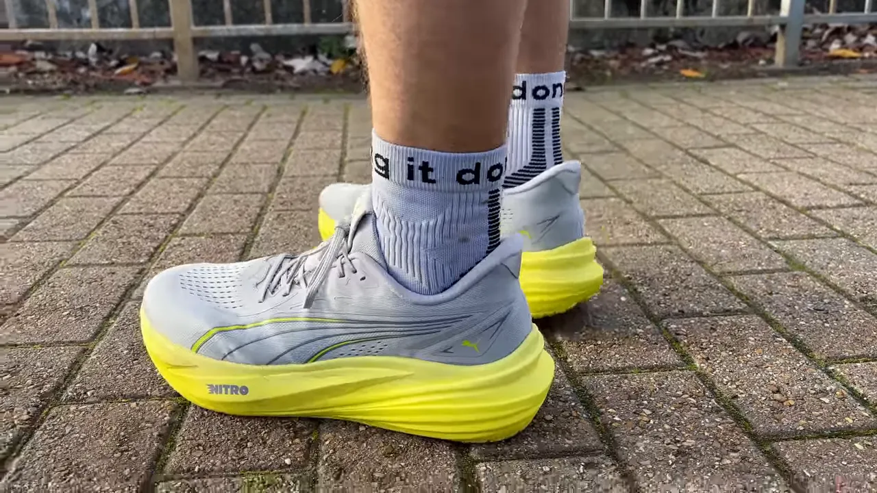Runner mid‑stride wearing Puma MagMax 2 showing bright yellow Nitro midsole on road
