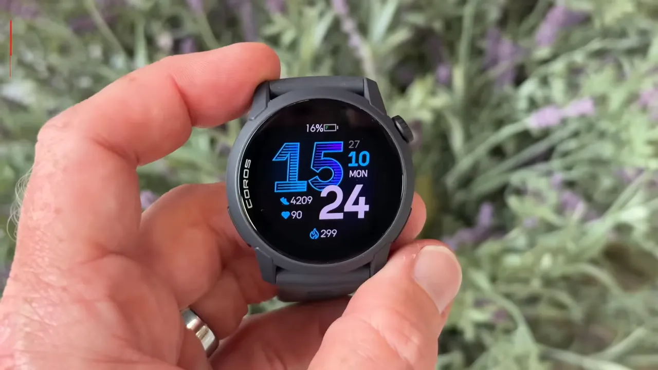 Close-up of the COROS Pace 4 being held toward the camera showing the watch face and light-colored strap