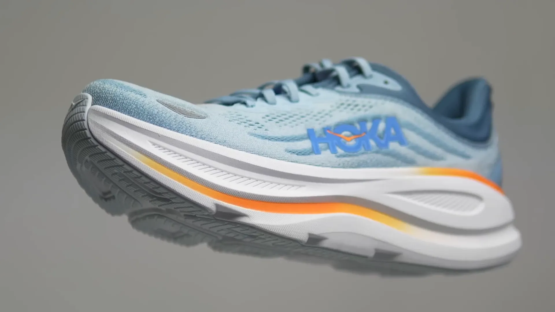 Hoka Clifton 9 shoes. Close-up shot of the shoes with a white midsole and a light blue upper, with the Hoka logo and the Hoka name.