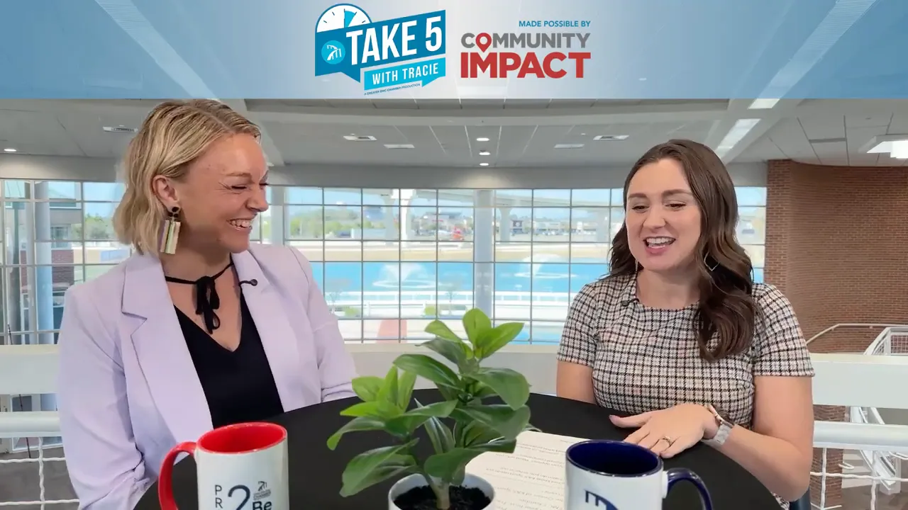 Two women in a studio interview at a round table with plant and mugs in foreground, Take 5 with Tracie banner above